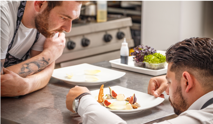 two men examining a prepared meal