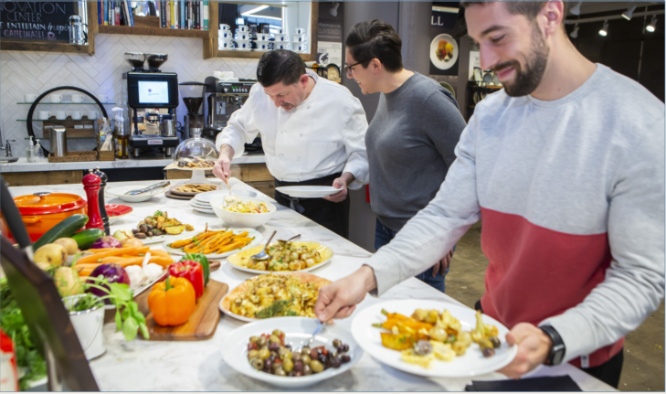 Man scooping a serving of olives on to his plate