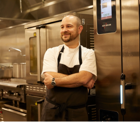 Man standing in front of metal stove