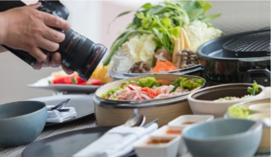 Food being on display in multiple containers being photographed