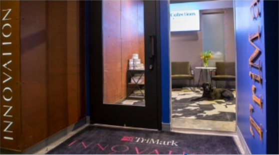 Door with a glass window inside a frame displaying an inviting entrance to an office space