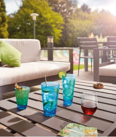 Outdoor patio with a couch and Glasses with drinks on a table 